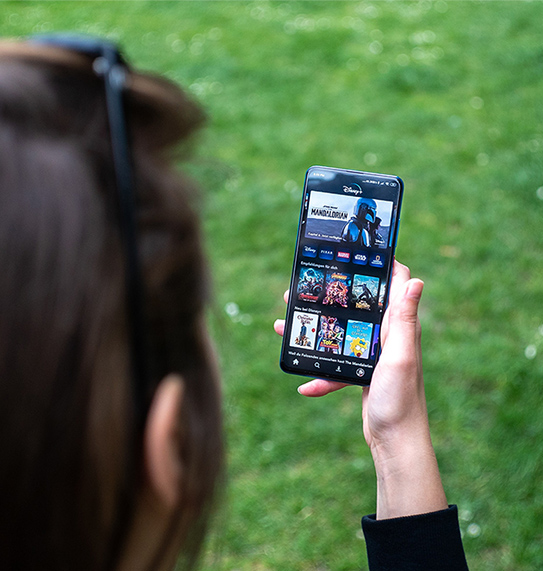 A man streaming videos on an OTT platform using his mobile device.