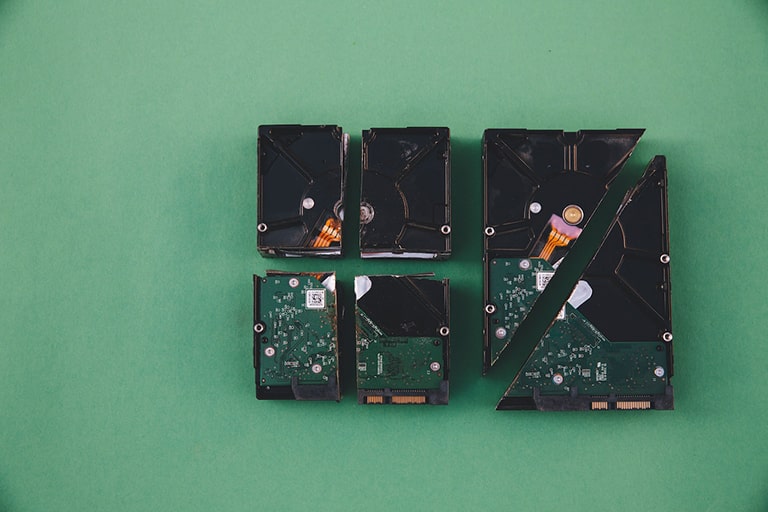 Broken HDD placed on a green surface, symbolizing the transition to the future with SSD technology leading the way.
