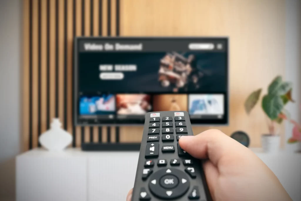 Content Consumption Trends in India: TV Remote in Hand Against Blurred Background
